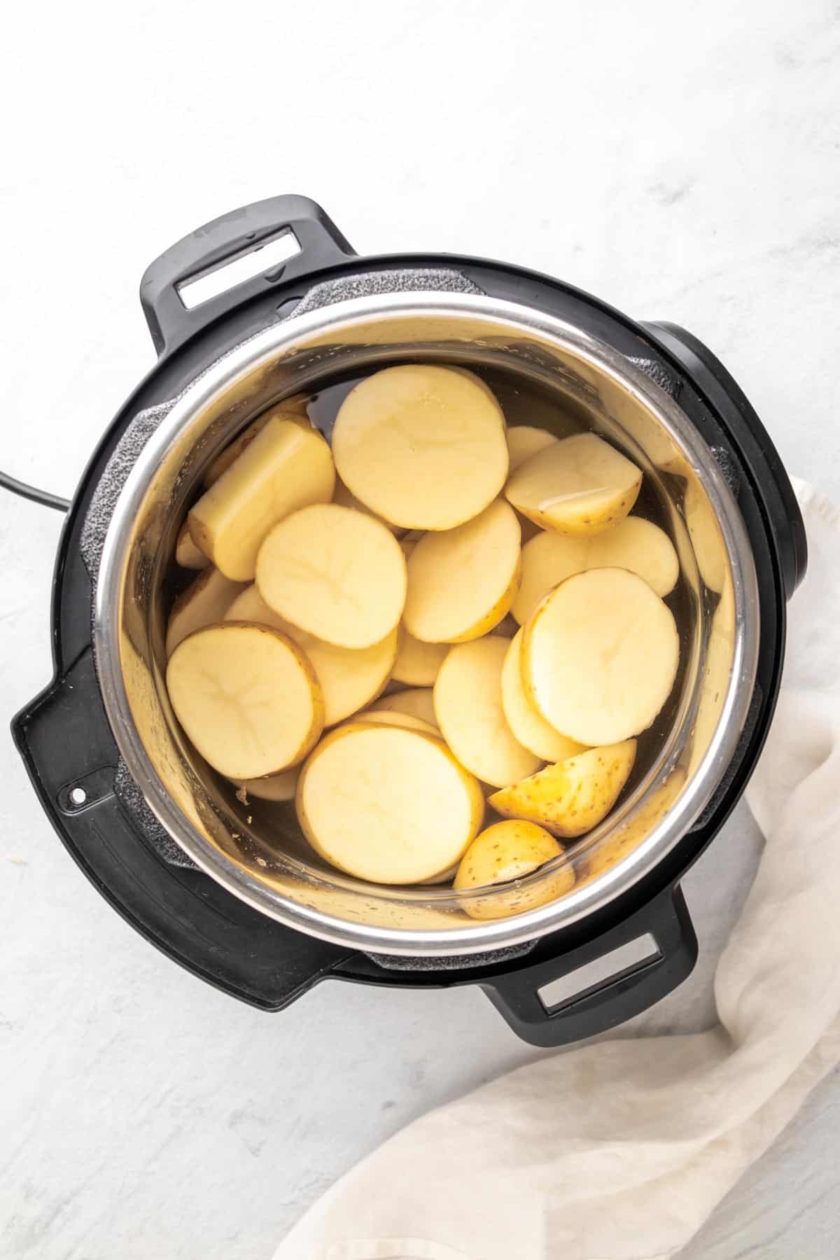 uncooked potatoes in the instant pot covered with water