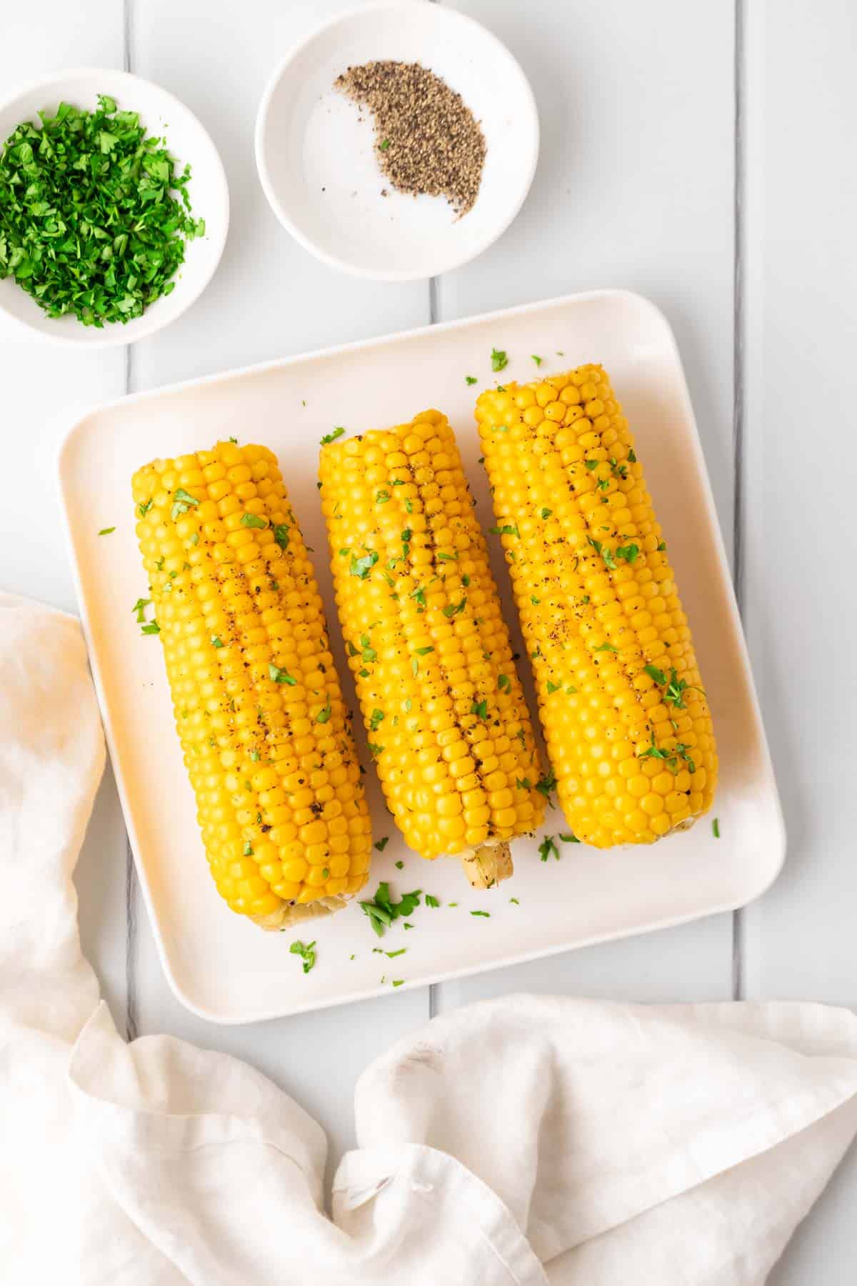 air fryer corn with hebs on a square plate