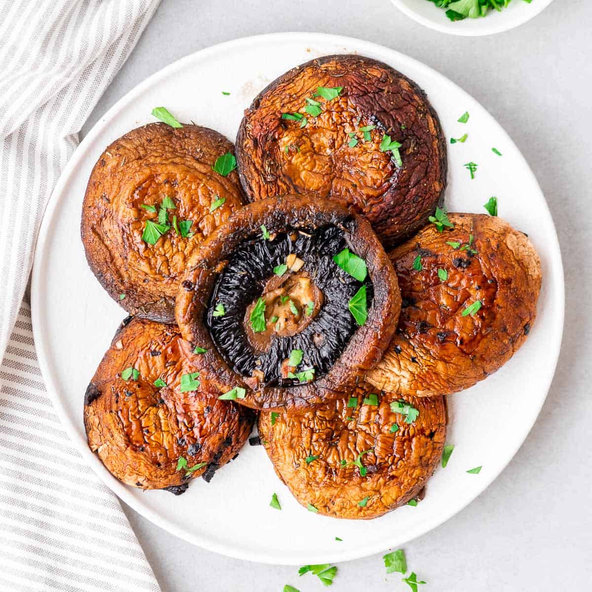 air fried portobello mushrooms served on a plate and garnished with fresh herbs