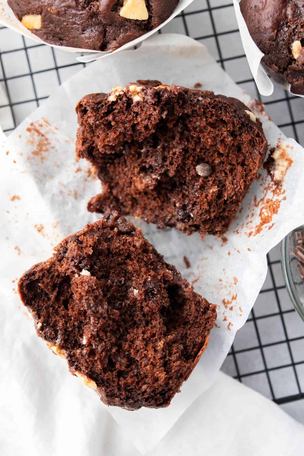 a chocolate muffin broken in half on baking paper