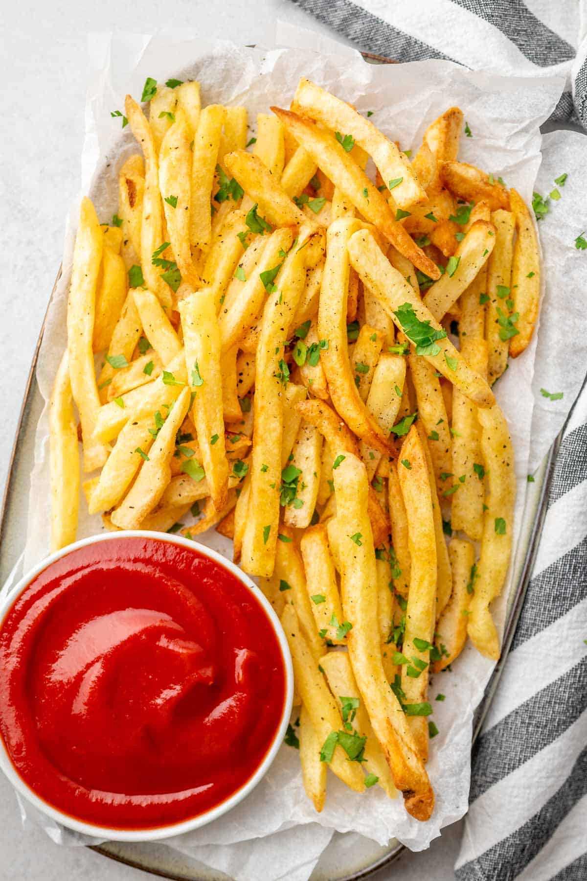 crispy fries garnished with herbs served with ketchup