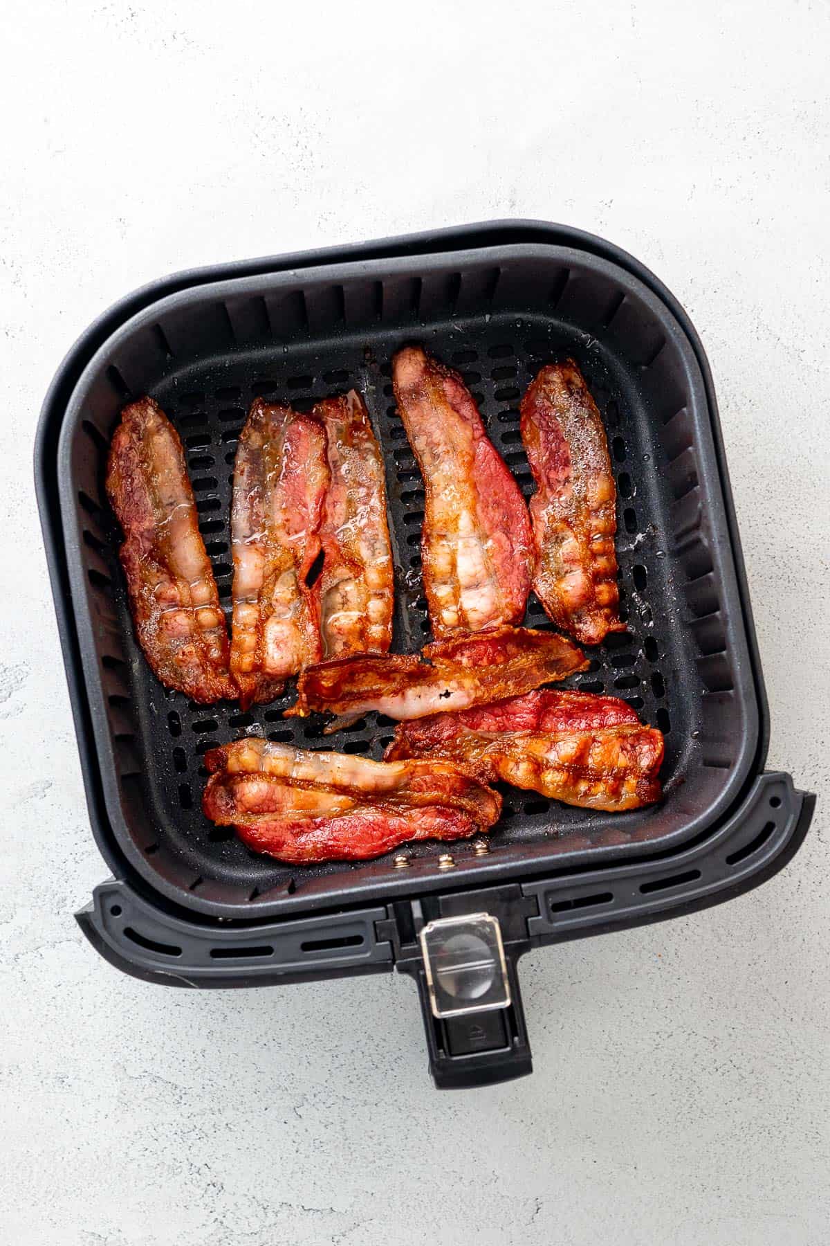 perfectly cooked strips of bacon laid out in the air fryer