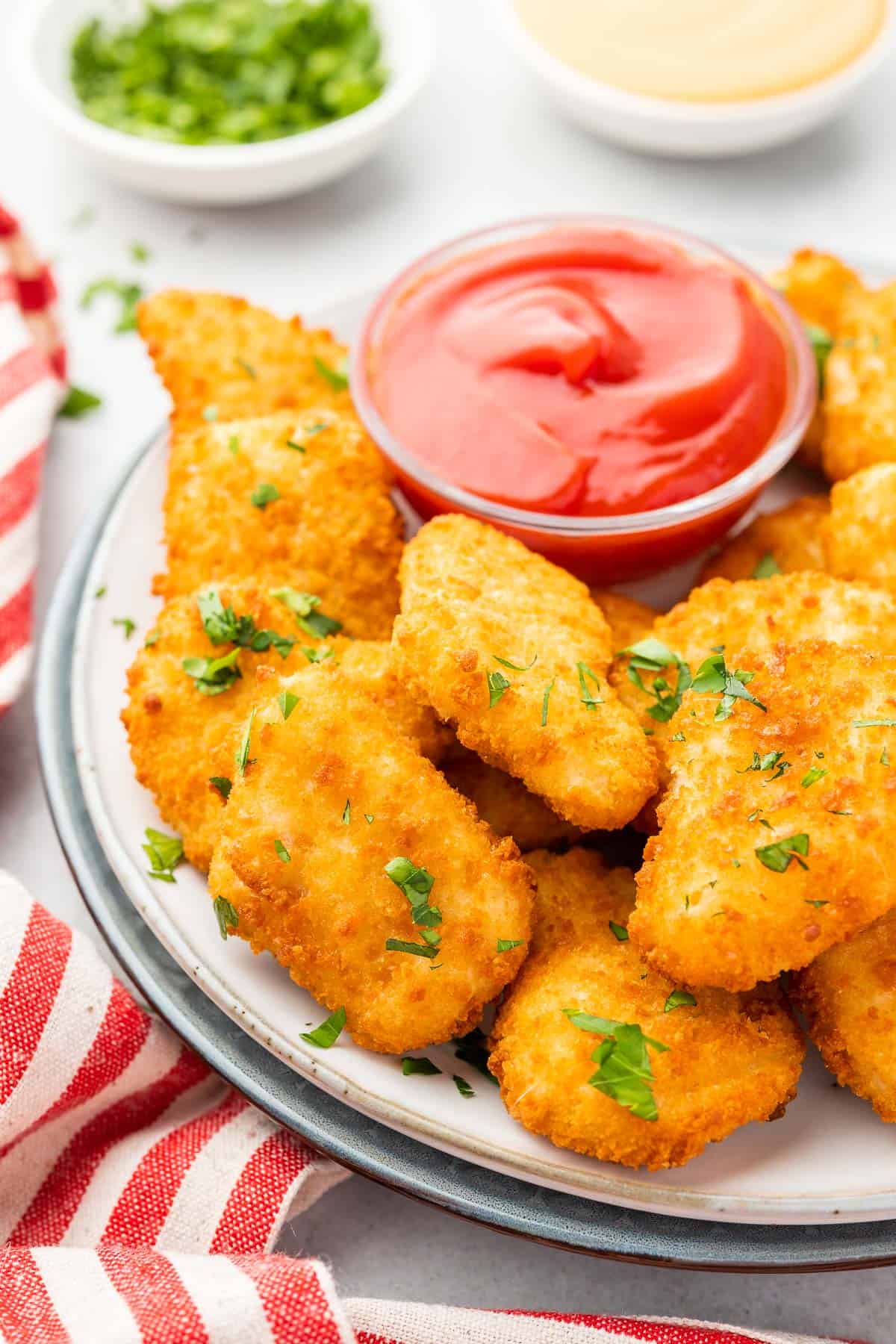 close up of the chicken nuggets arranged on a plate around a bowl of ketchup for dipping