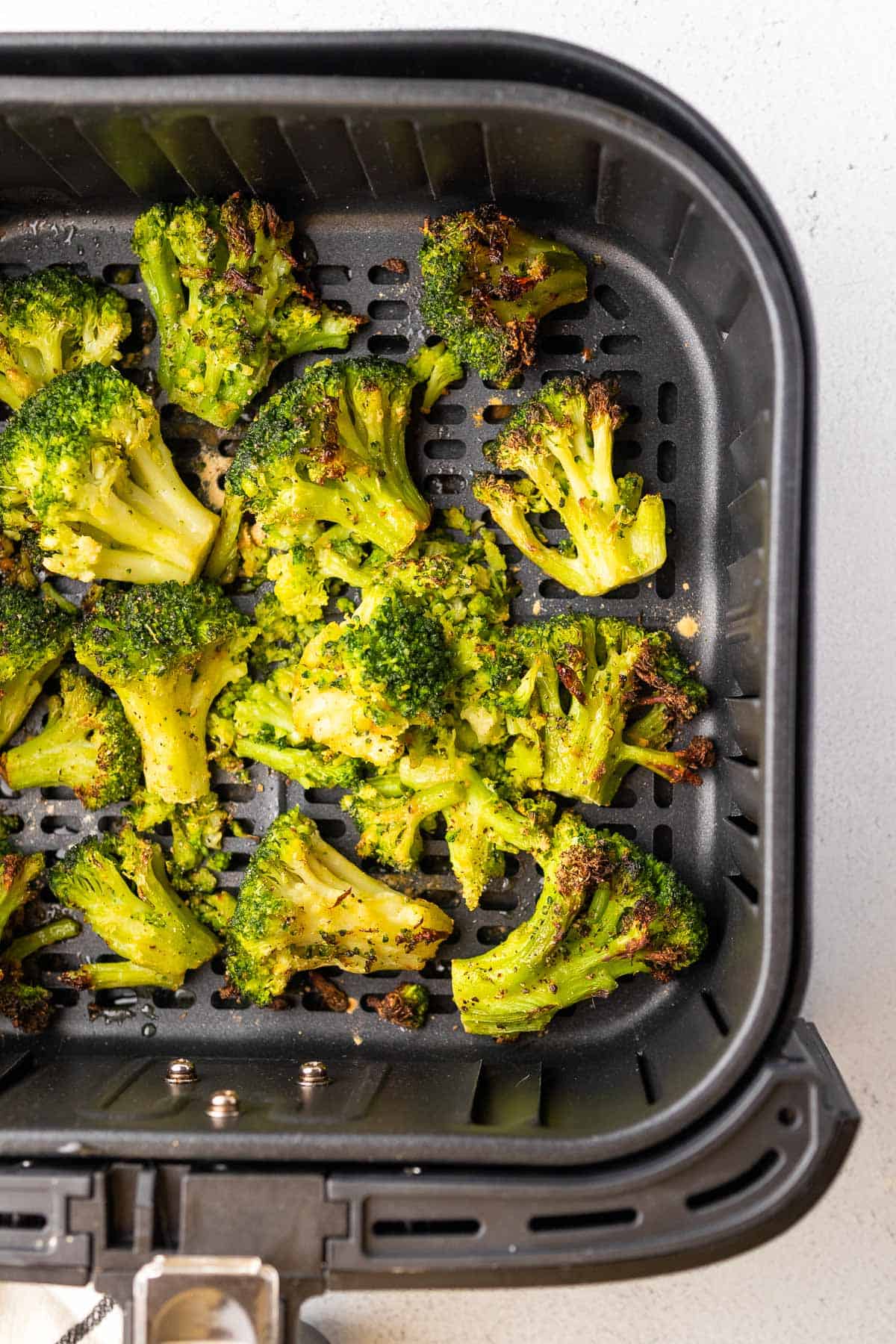 cooked broccoli in the air fryer basket before being served