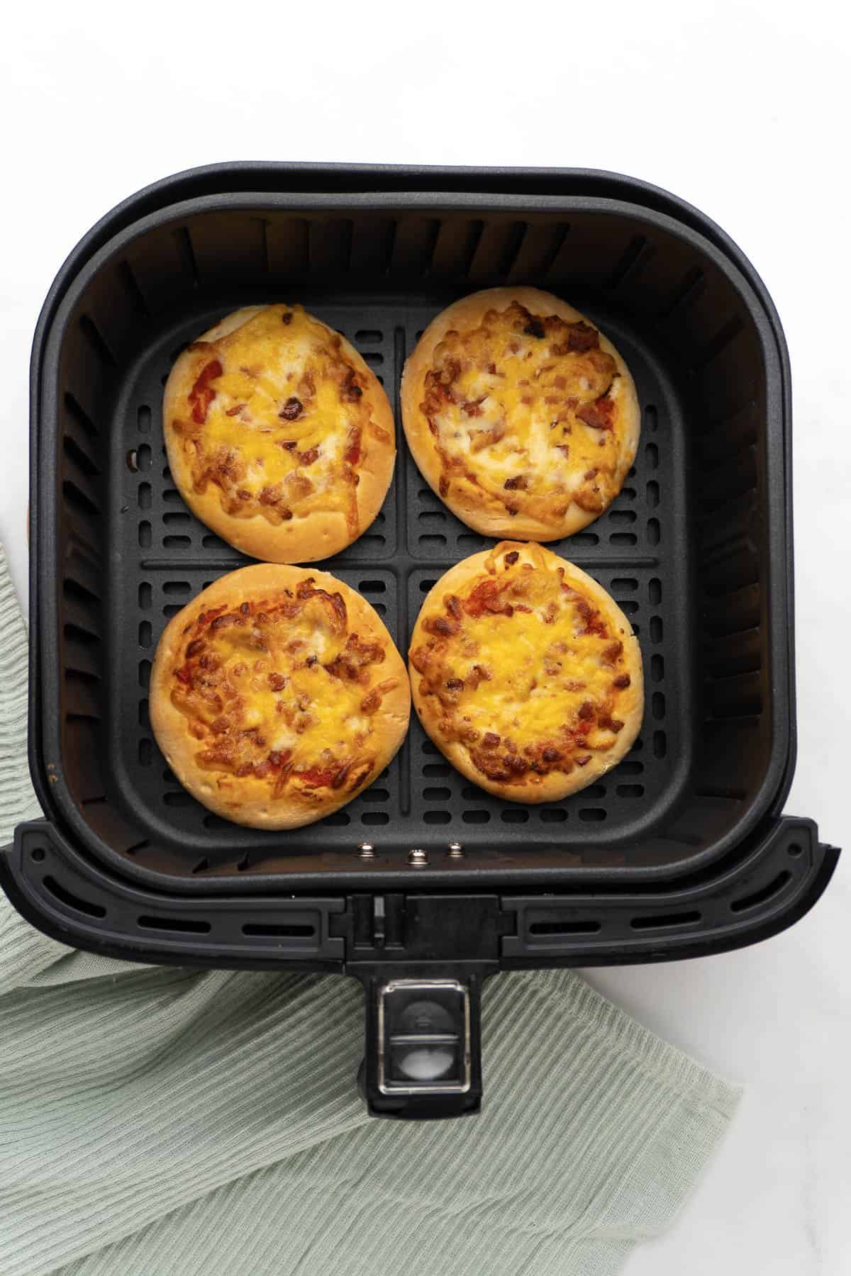 four mini pizzas in the air fryer after being cooked