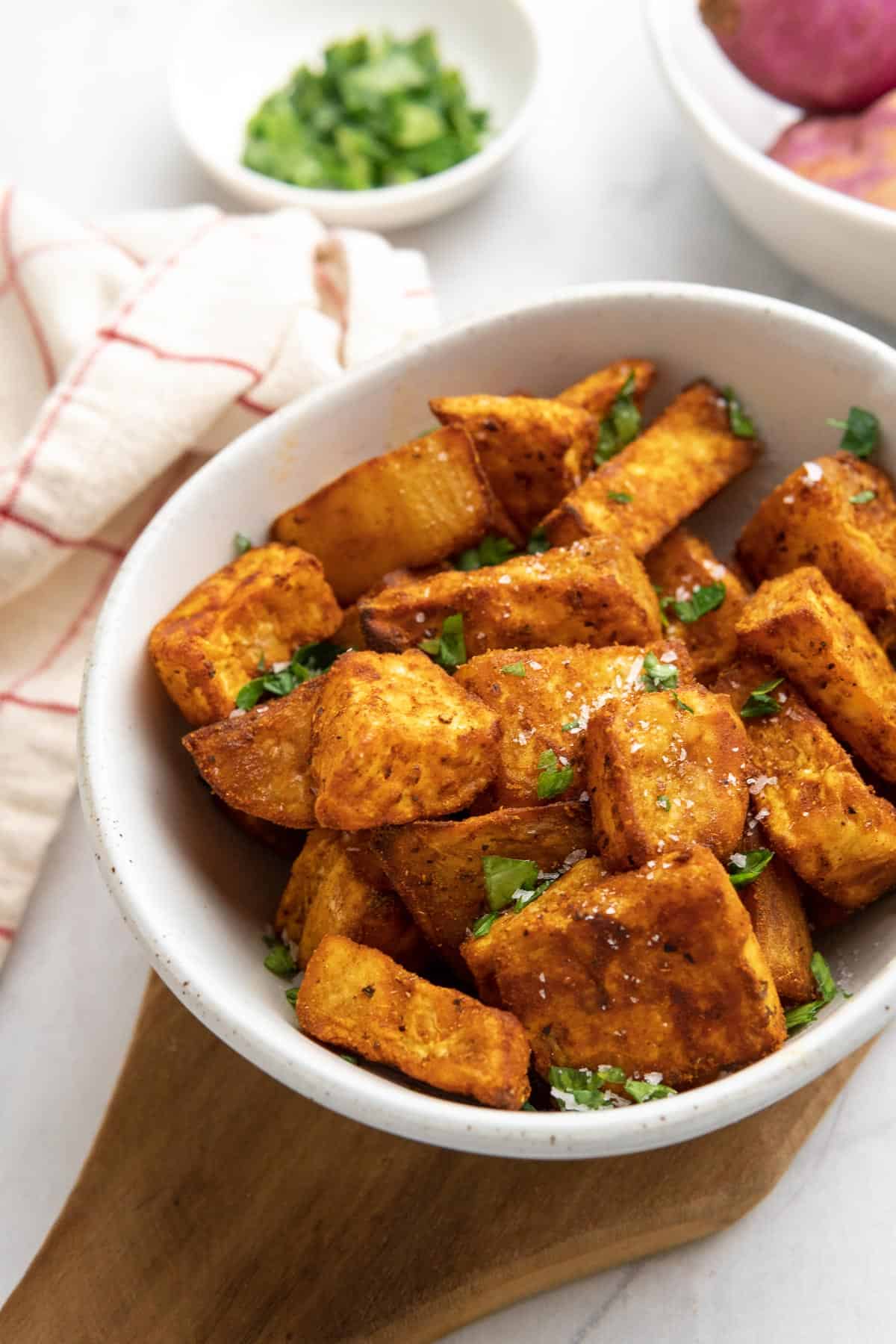 featured image for the air fryer sweet potato cubes in a bowl served with salt flakes and fresh herbs 