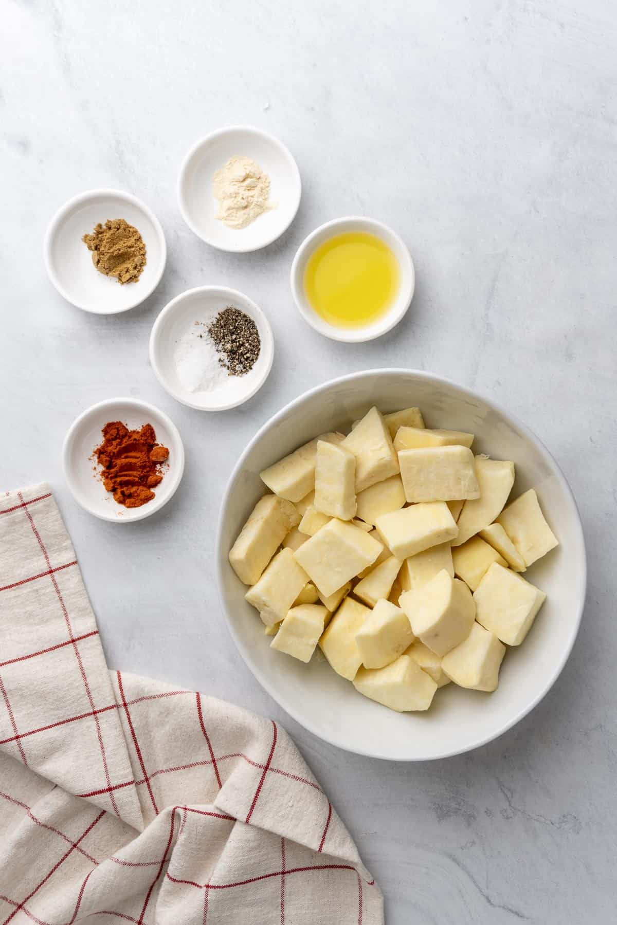 ingredients for the air fryer sweet potato cubes laid out in small white dishes and bowls 