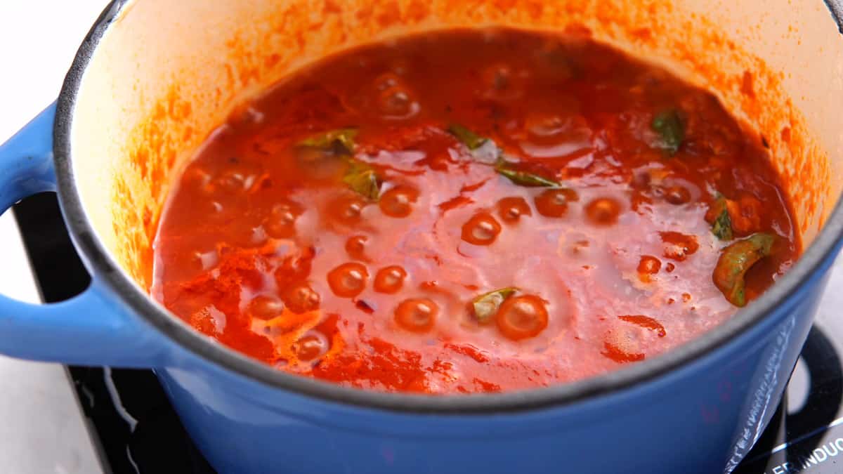 tomato sauce simmering in a blue pot 
