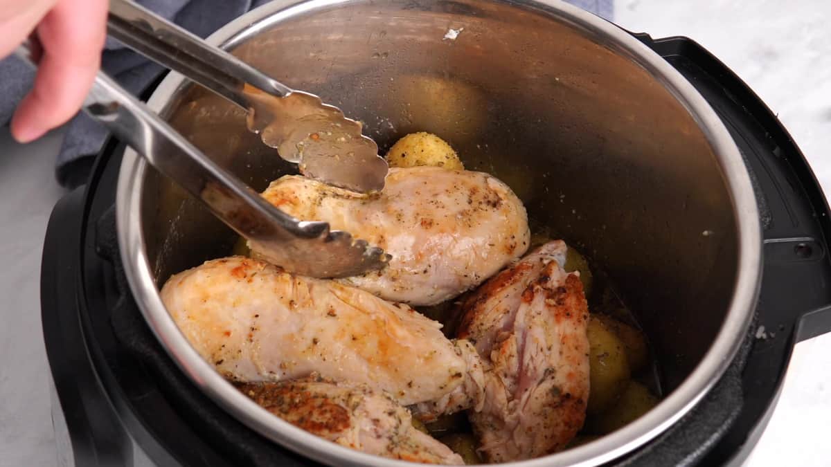adding the chicken on top of the potatoes in the instant pot 