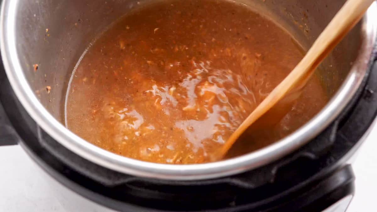 mixing the bubbling gravy in the instant pot 