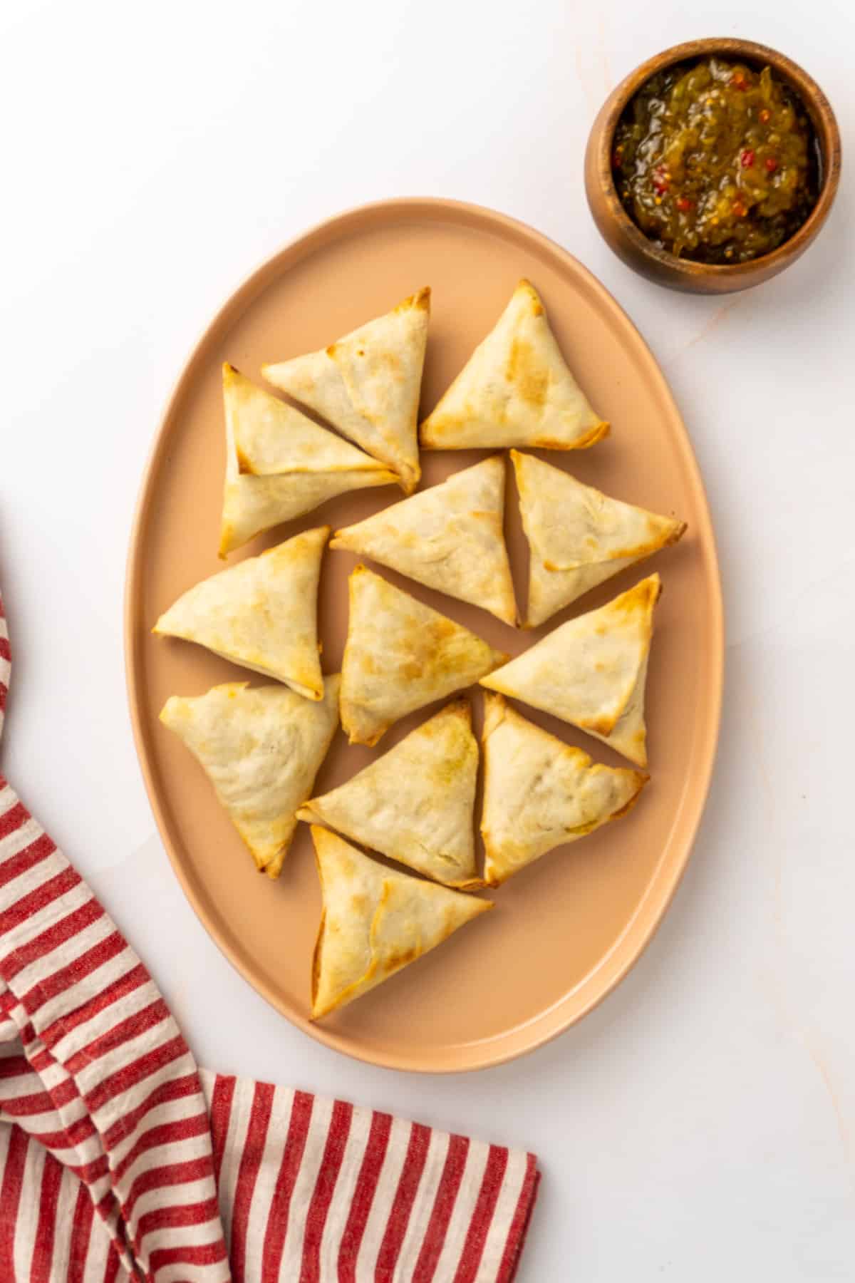 cooked samosas laid out on a serving plate