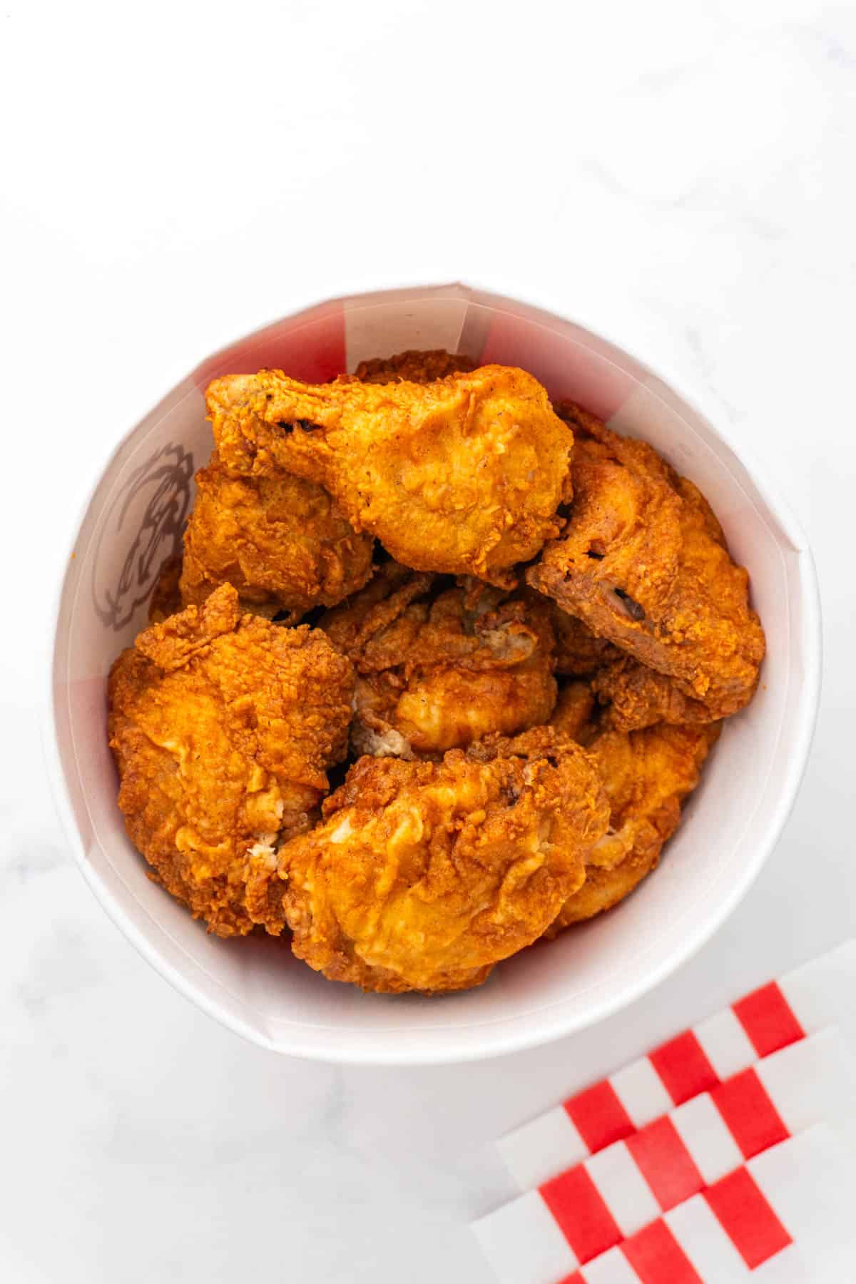 A bucket of Kentucky fried chicken on a white background. 