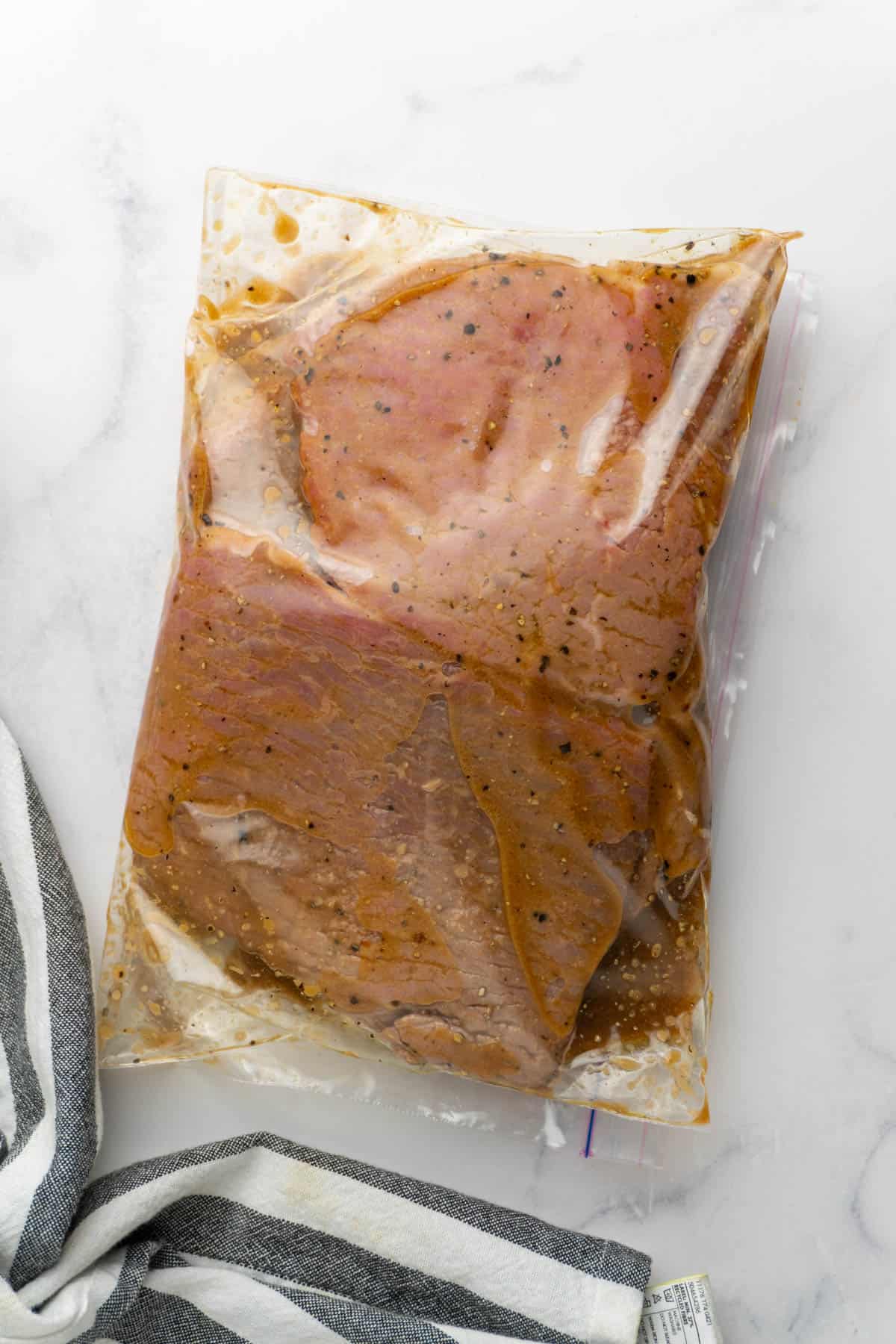 Cube steaks in a sealed zipper bag are marinating.