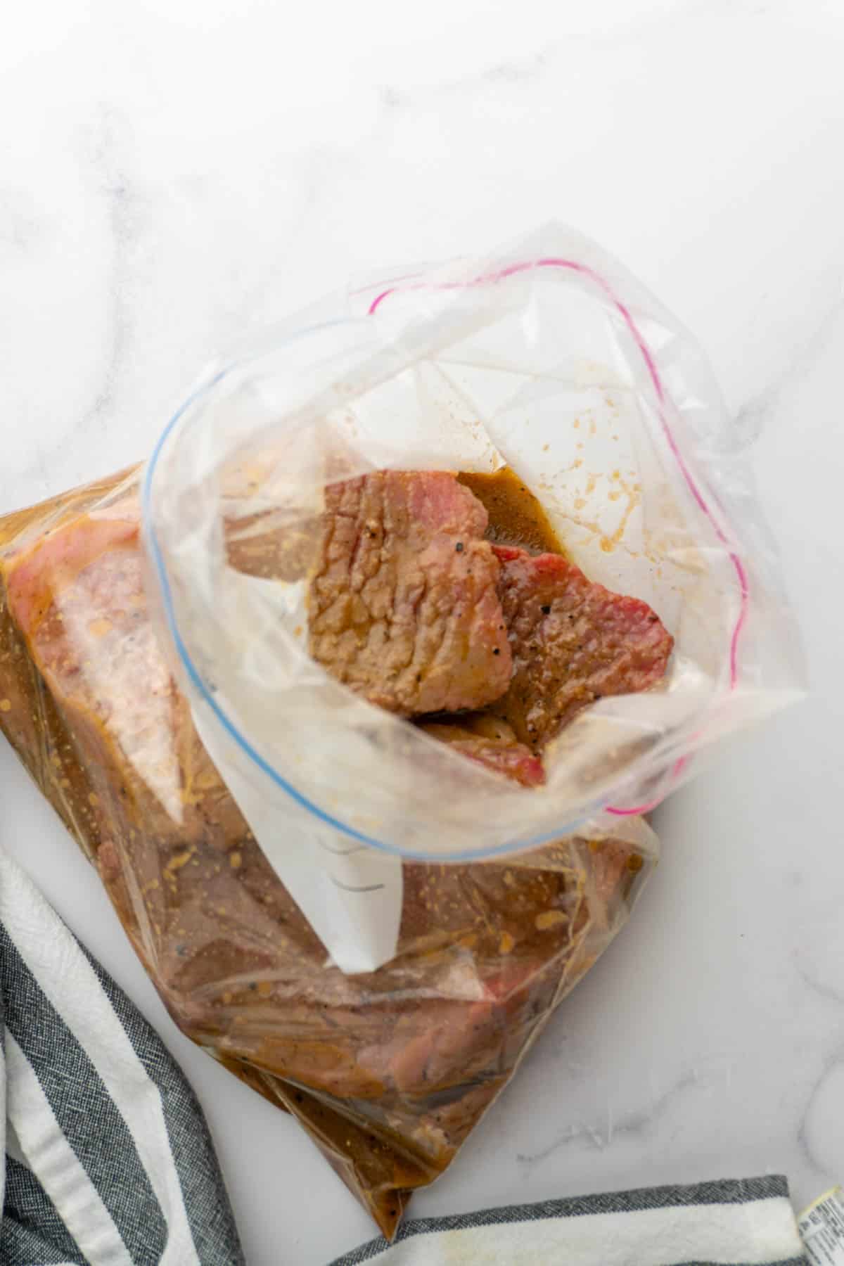 Cube steak in the marinade inside the plastic bag.