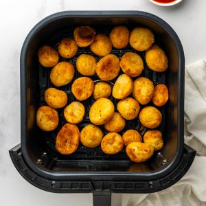 Close up of the crispy roast potatoes in the air fryer basket.