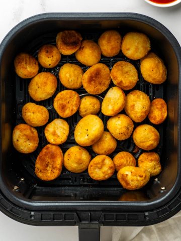 Close up of the crispy roast potatoes in the air fryer basket.
