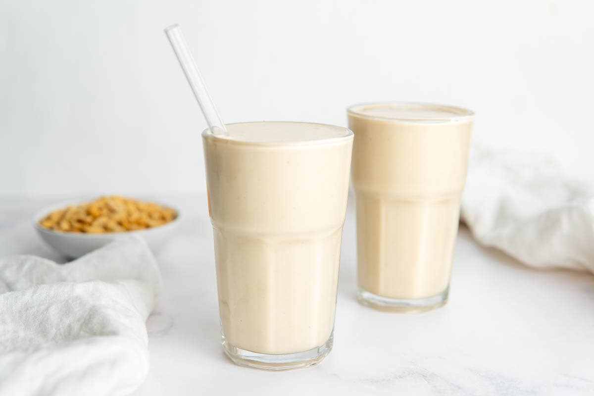 Two glasses filled with the peanut butter smoothie. 